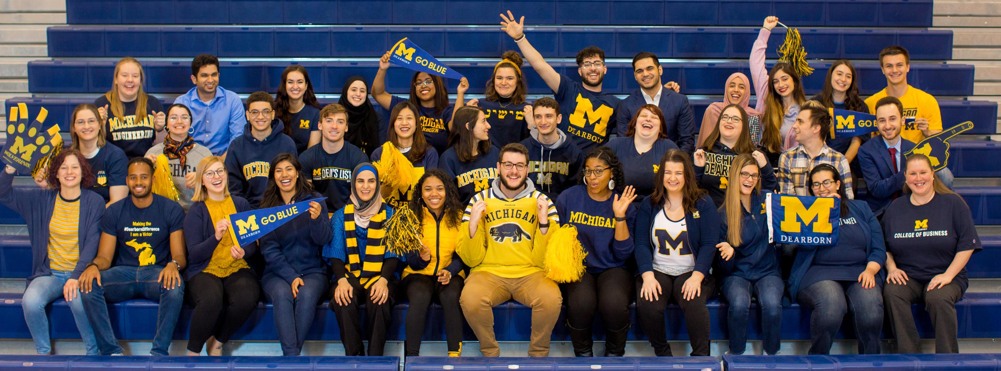 2019 Difference Makers A group of students cheering, seated in bleachers.